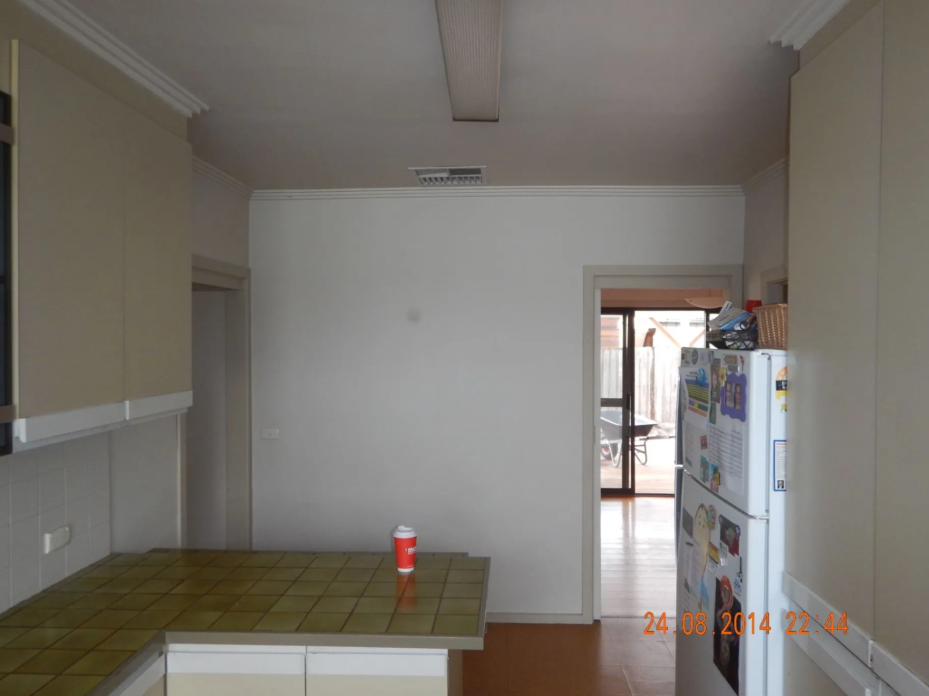 Existing Bentleigh East kitchen with tiled island and view through to the rear deck