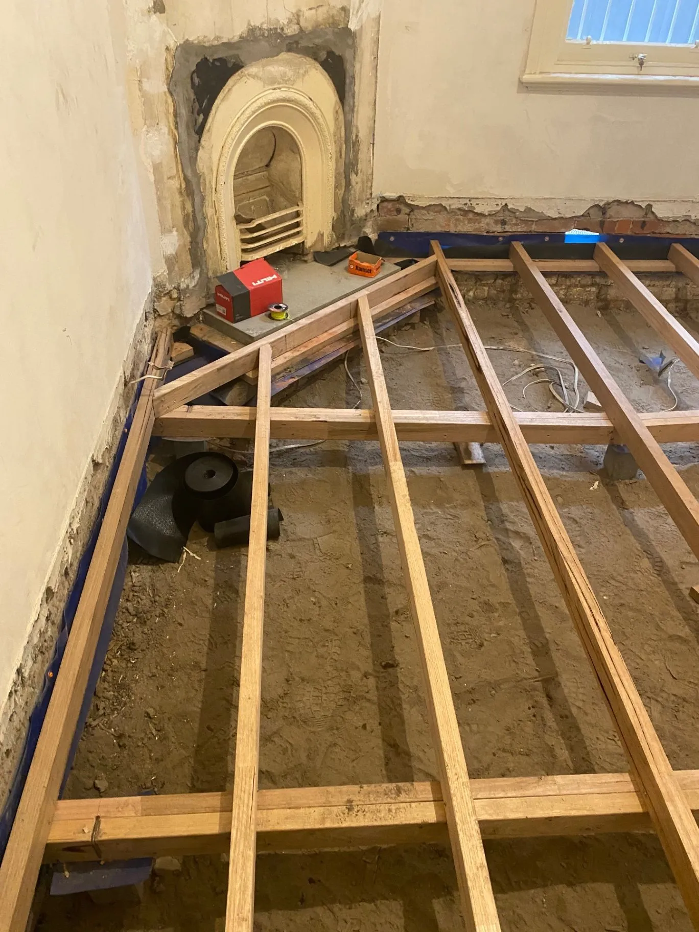 Timber subfloor framing installed beside a fireplace during Elsternwick repair work